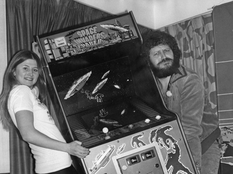 BBC Radio 1 presenter Dave Lee Travis helps Mandy Strong carry a Space Invaders arcade machine in November 1979. Strong had won the machine at a charity concert and it was presented to her by the DJ.