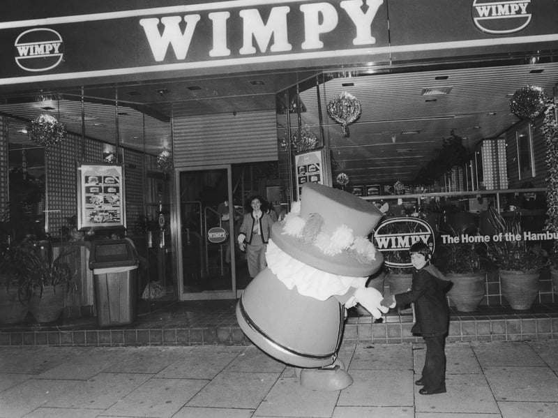 The Wimpy Beefeater mascot welcomes guests to a children's party at a new Wimpy Bar in December 1978