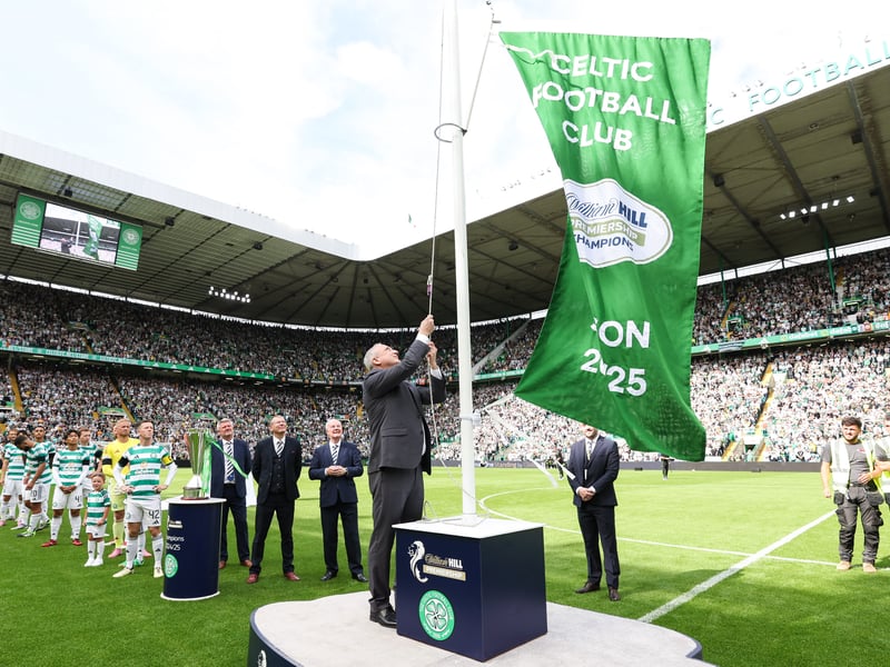 Celtic legend Paul McStay unfurls the 2024/25 Premiership league winners flag.