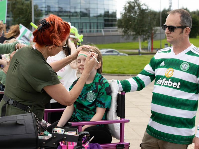 A young fan gets her face painted as she gets ready to welcome the team to Celtic Park.
