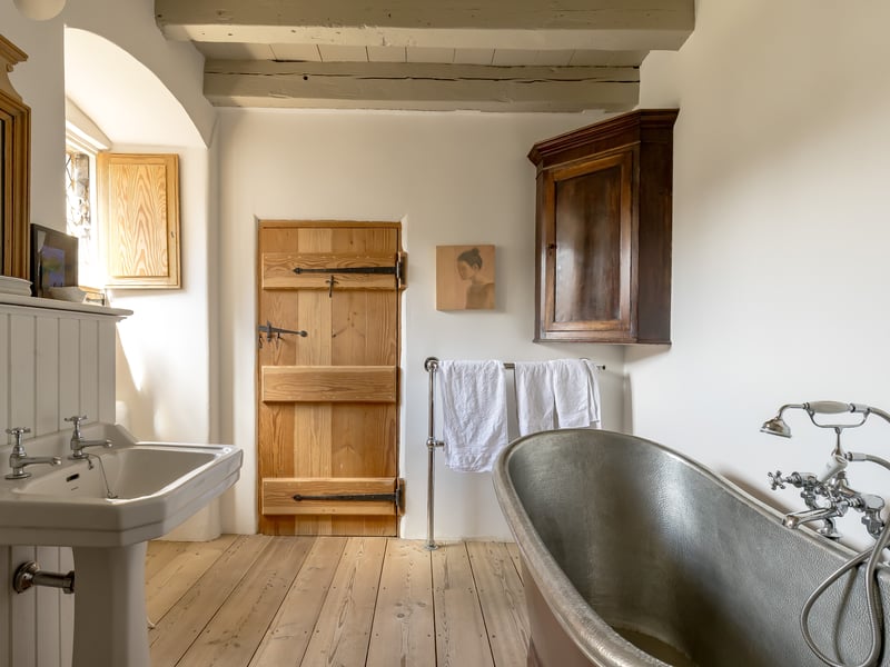 The interior style mixes original features - such as these huge ceiling beams - with carefully-sourced modern pieces. 