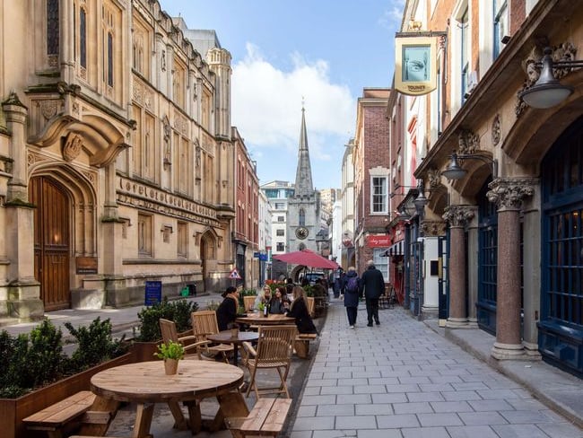 Broad Street is one of the original main streets of Bristol. Merchants would set up their stalls on Broad Street before The Exchange was built. St John's Gate (and the Church of St John the Baptist) at the bottom of the street is the last remaining part of the city wall.