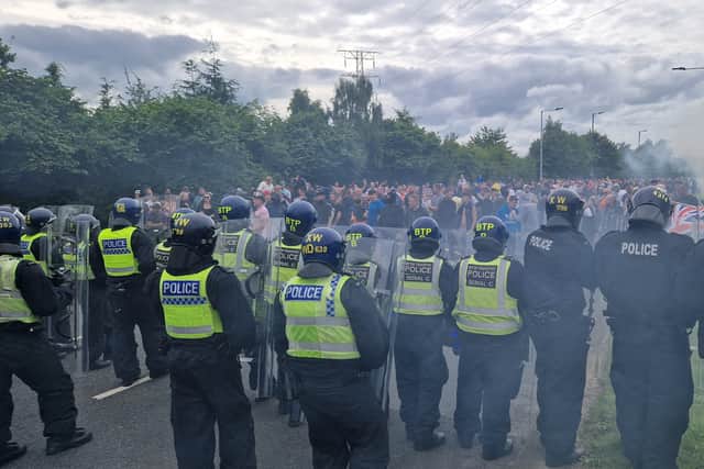 Police hold back rioters at the Holiday Inn Express in Manvers, Rotherham