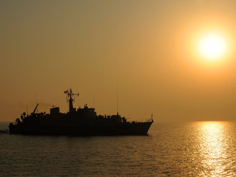 HMS Pembroke in the Middle Eastern sunset during the Officer Of the Watch manoeuvres. The minehunter was regularly deployed in the Gulf to clear explosive ordnances and other obstacles.