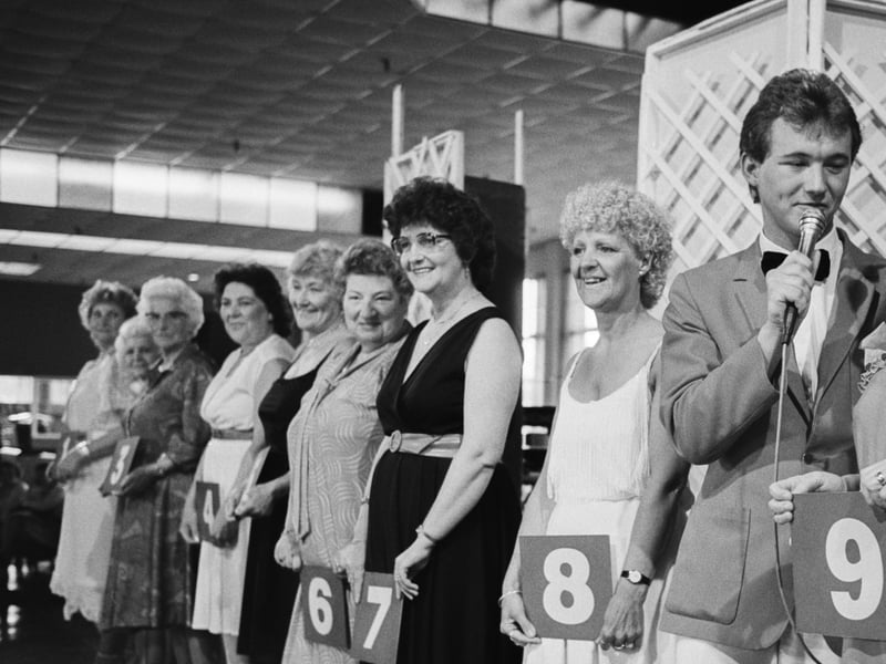 A Redcoat interviews a contestant in the glamorous grandmother competition at the Butlin's Holiday Camp in Bognor Regis, West Sussex, in June 1985