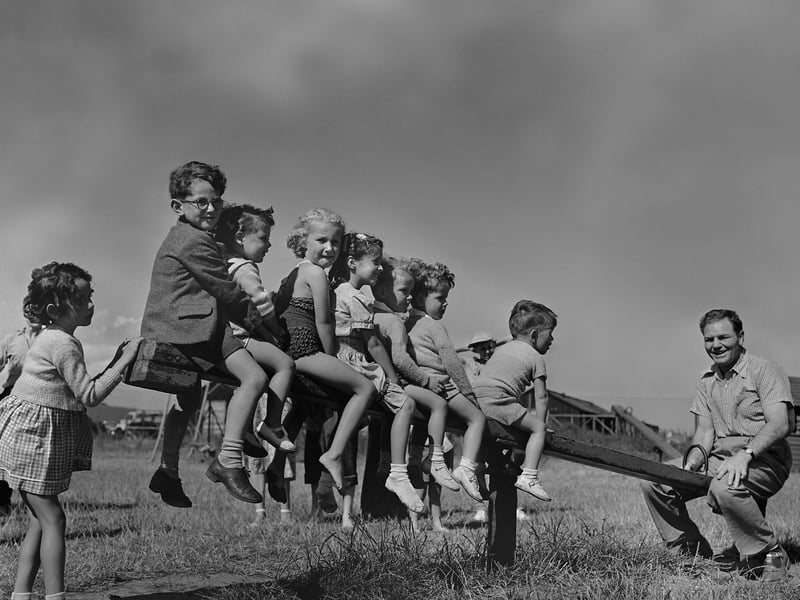 American heavyweight boxing champion Lee Savold outweighs a group of children on a see-saw at Butlin's holiday camp in Clacton, Essex, in July 1950
