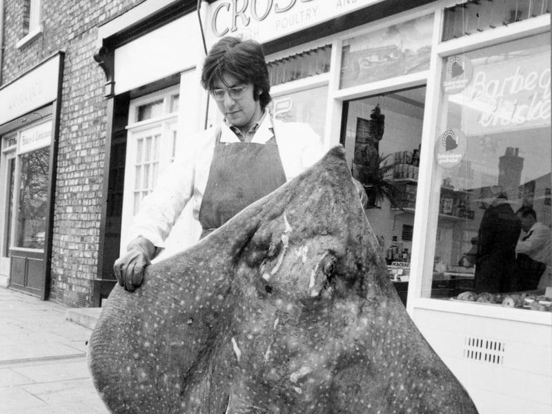 Eric Aaron, a shop assistant in York, holding a skate weighing 7.5 stone, which was landed off the Hull coastline in April 1976