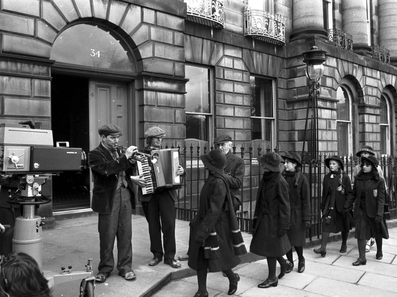STV filming their TV series 'The Prime of Miss Jean Brodie' in Moray Place, Edinburgh, in April 1977. The camera rolls as Geraldine McEwan and her 'gerls' walk towards a three-piece street band.
