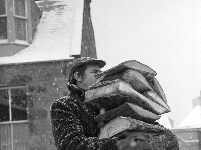 A Prestonpans miner carries logs to an OAP's home when coal stocks run low during the miners' strike of 1972