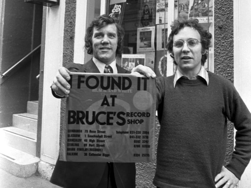 Owners Brian Findlay and Bruce Findlay with the distinctive red carrier bag 'I Found It At Bruce's' outside Bruce's Record Shop, on Rose Street, Edinburgh, in November 1972