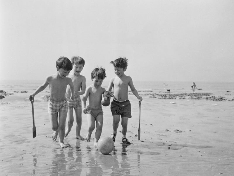A group of boys playing with a ball and spades, as they play on the beach at Saltdean, East Sussex, in 1962