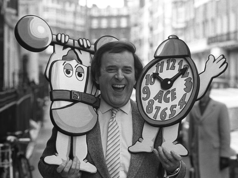 The radio and TV presenter Terry Wogan poses with an alarm clock in April 1984