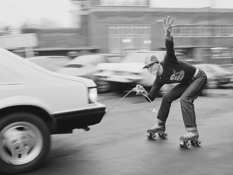 Roller skater Leo Bull hitches a lift using a cable attached to a car in December 1980