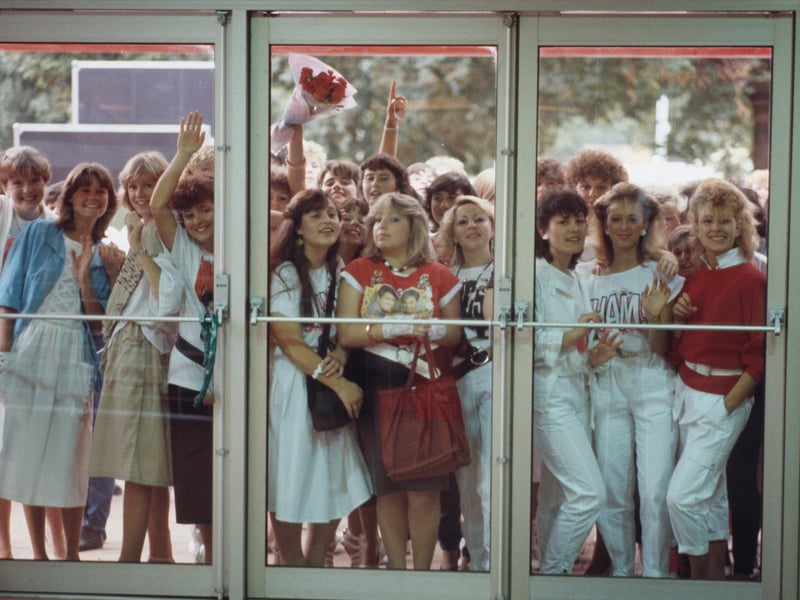 Teenage fans press their faces against the glass as they wait to see pop sensations Wham! in 1986