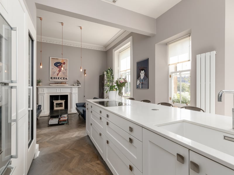 The south-facing kitchen has large sash-and-case windows.