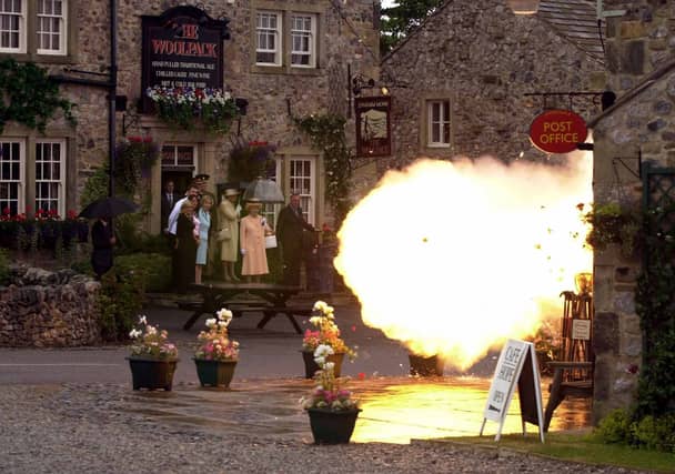 The Queen looks on as the post office explodes on the set of Emmerdale in July 2002.