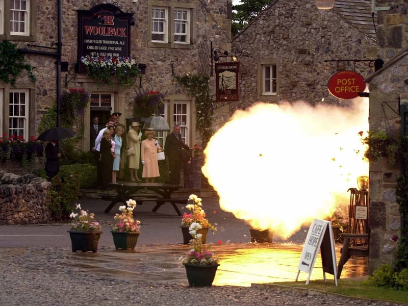The Queen looks on as the post office explodes on the set of Emmerdale in July 2002.