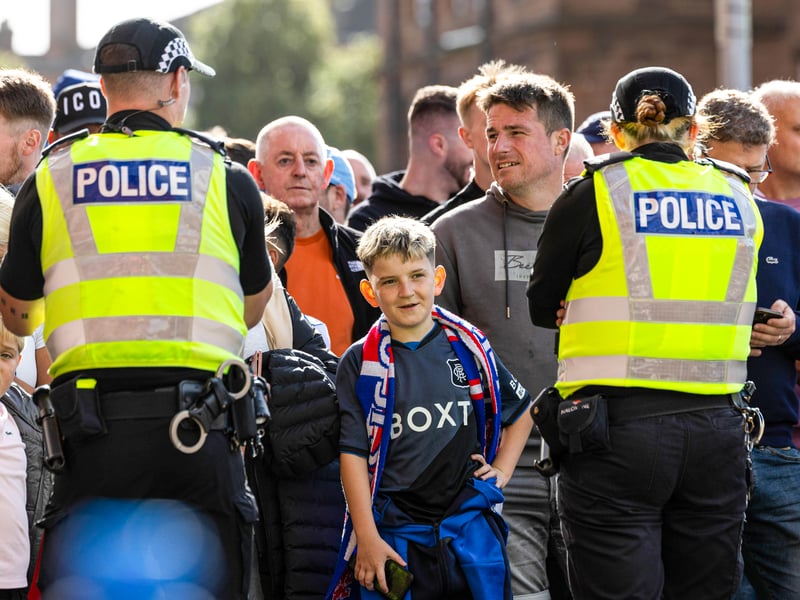 Rangers fans watch the team busses arrive.