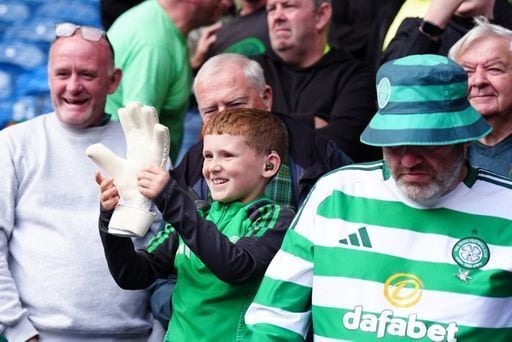 A young Celtic fan with the gloves of Celtic goalkeeper Kasper Schmeichel after the final whistle.