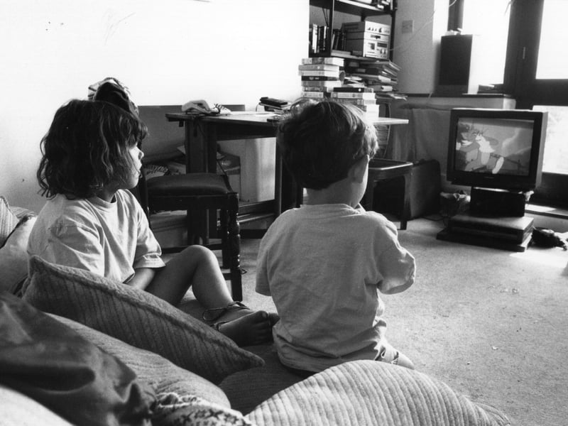 Two children watching a Tom And Jerry cartoon on TV in August 1995