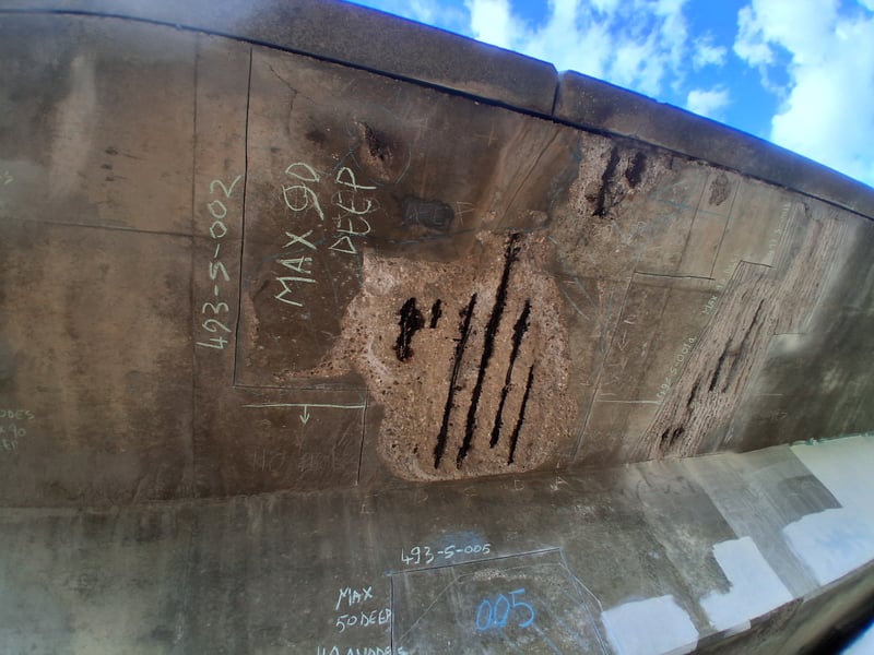 The metal work showing through the concrete prior to the repairs.