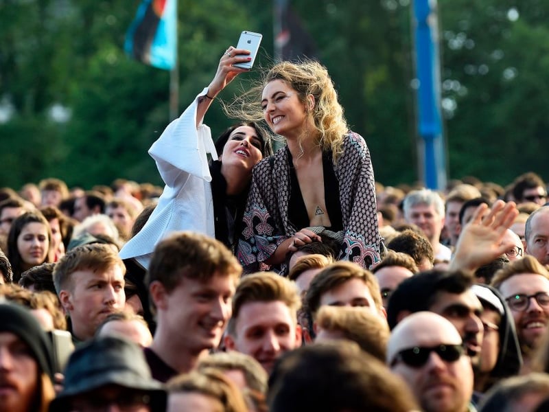 Fans in the crowd take a selfie.