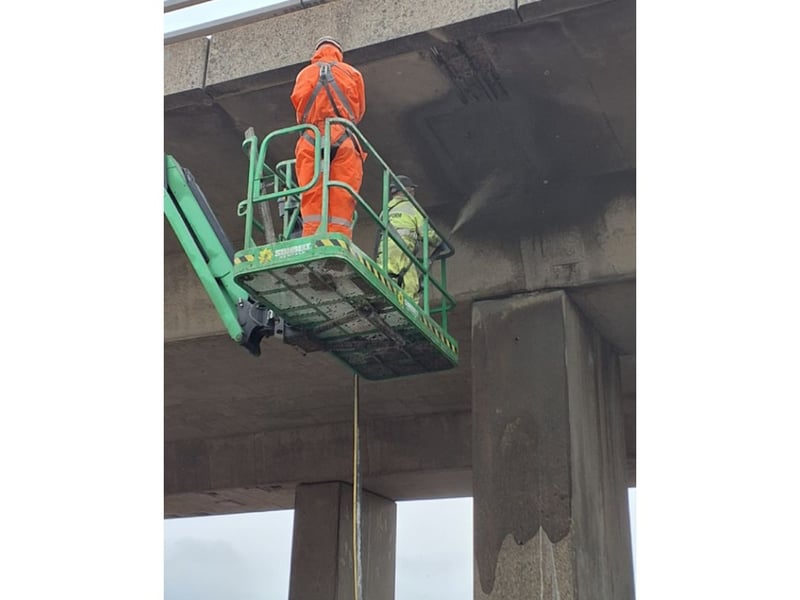 Spray concrete being applied to repair areas under the bridge.