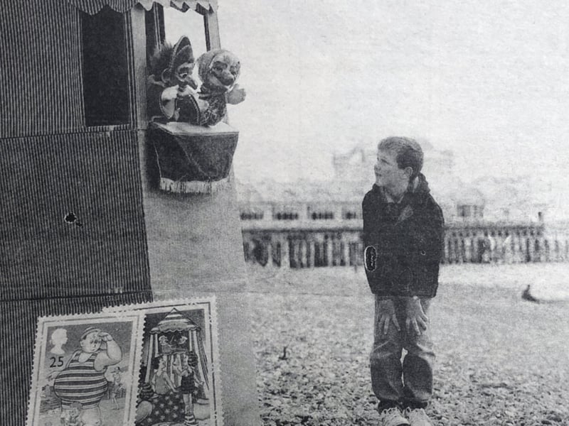 A lone child, eight-year-old Robert Conway, watches a Punch and Judy show on Southsea beach, during the launch of new stamps celebrating 100 years of Britain's cheeky picture postcards