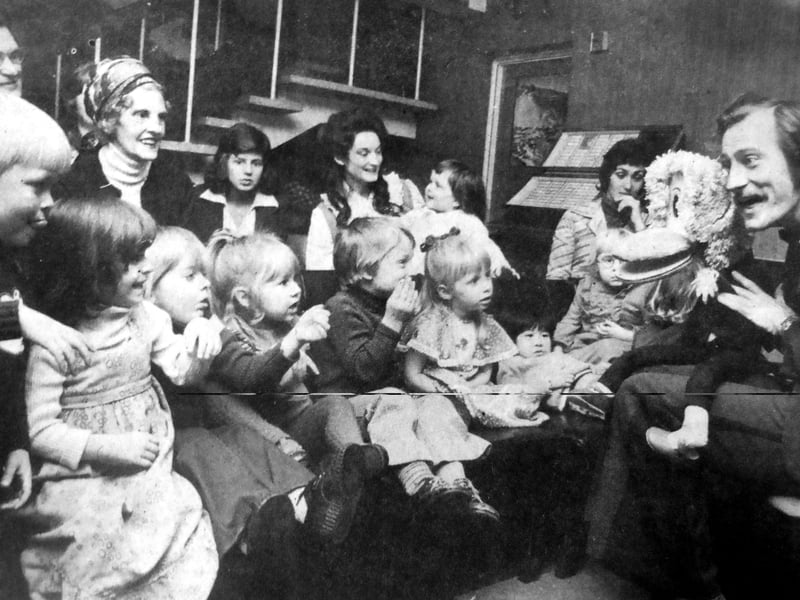 Magician Christopher Cox and Herbert the Duck hold the attention of children attending the under-five playgroup's Christmas party at the Brook Club, Southsea, in 1975