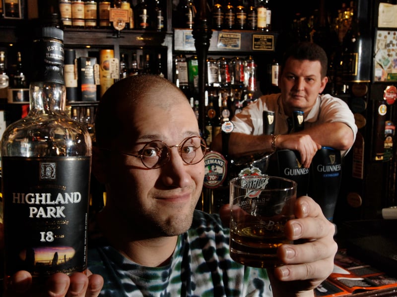 John Wheeler, Hayseed Dixie front man and Scotch whisky appreciator, pictured in 2006 enjoying a dram in Glasgow's Pot Still bar, with pub owner Ken Storrie