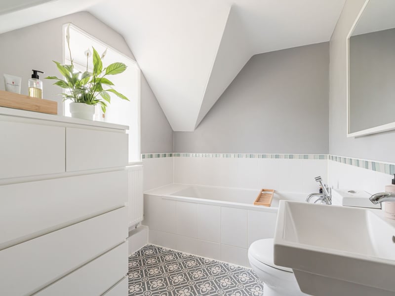 The large three-piece modern en-suite bathroom comes with built-in storage, with a quaint porthole-style window with views across to Fife.