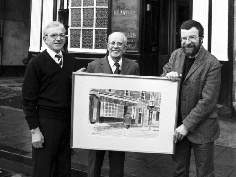 Edinburgh University's artist in residence John McLean (right) presents a painting of Stewart's Bar to the landlord (left) and George Stewart, son of the original owner. This picture was taken outside the Drummond Street pub (now renamed the Brass Monkey) in March 1986.