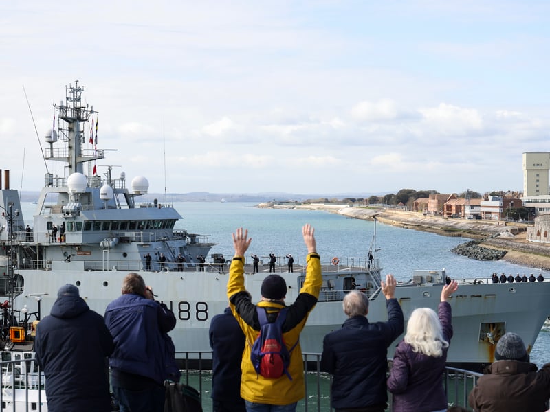 Pictured: Ship's company of HMS Enterprise wave to the public as they sail into Portsmouth, flying its decommissioning pennant.