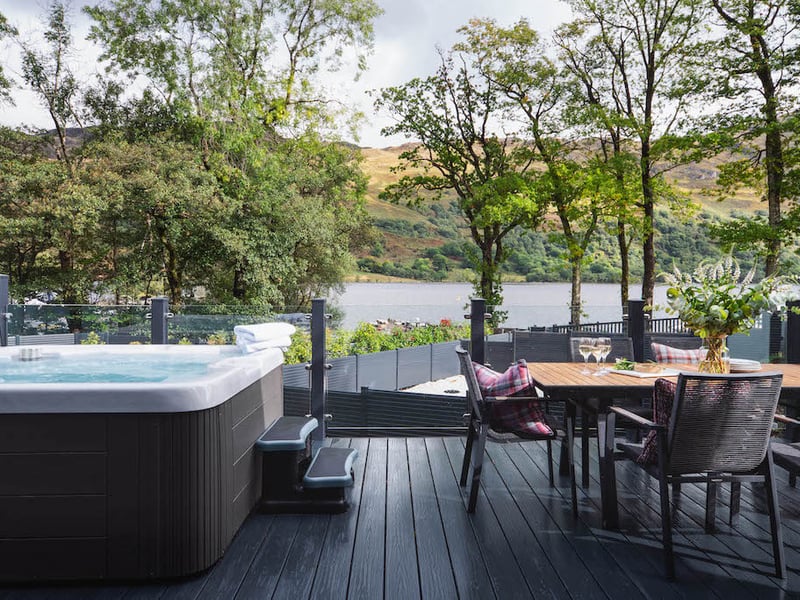 Fancy relaxing? The luxury retreat boasts an outdoor hot tub as well as a dining space with loch-side views.