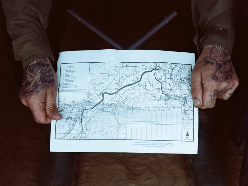 A fisherman visiting from Northern Ireland holds a beat map downstream from Boat of Garten.
