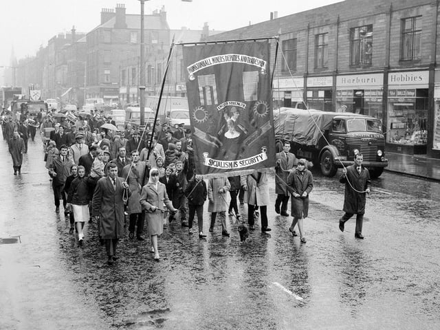 Miners and their families parade down Leith Walkin the rain  on their way to Leith Links for the Miners Gala Day in 1965.