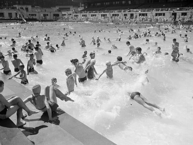 Holiday-makers at Portobello outdoor swimming pool,  Edinburgh, having fun in the waves created by a special machine in July 1955.