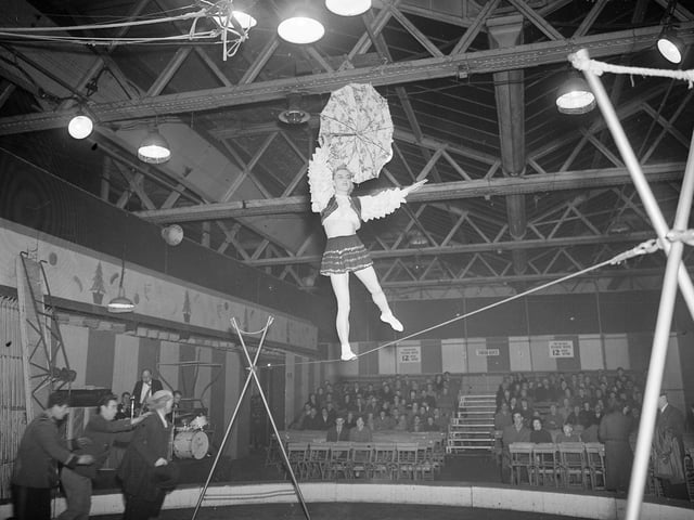 A tightrope walker balances above the ring at a circus in Waverley Market, Edinburgh, in January 1955.