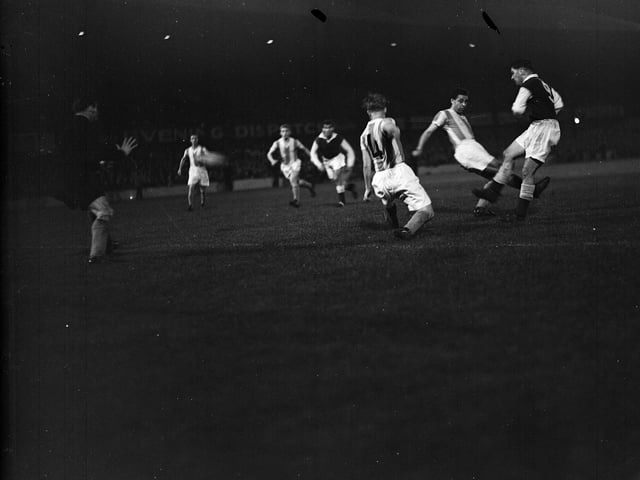 In 1955 Hibs became the first British team to enter European competition. In the first round of the European Cup they were drawn against German champions Rot Weiss.  In the second leg Jimmy Mulkerrin of Hibs has a shot blocked by Vorderbaumen and Wewers.  The game ended 1-1 after Hibs had won the first game in Essen 4-0.