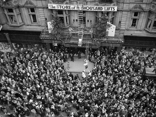 Crowds outside Patrick Thomson's department store in Edinburgh as  Santa Claus climbs down a golden ladder in November 1955 . The shop advertised itself as 'The Store of a Thousand Gifts'.