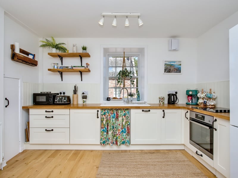 The kitchen is a modern shaker style with plenty of storage,