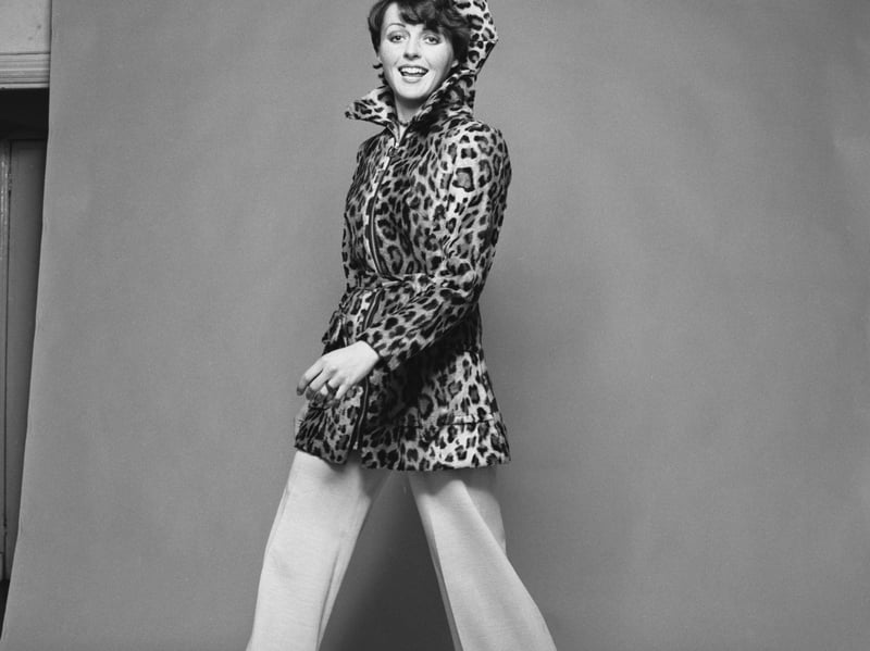 A model wearing a leopard print coat and flared trousers, in December 1971