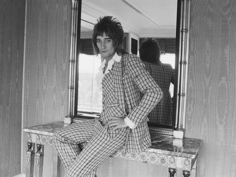 Rod Stewart is seen here posing beside the mirror in a checked suit, in September 1974