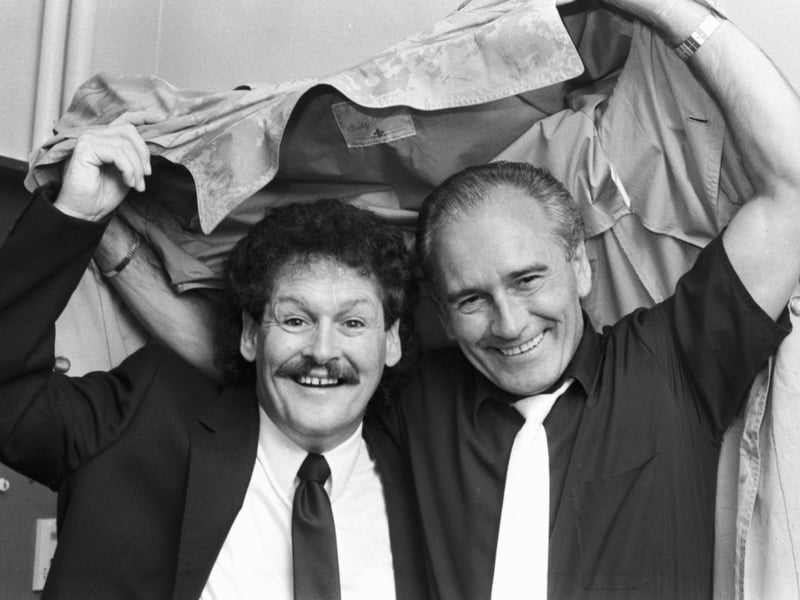 Tommy Cannon (right) and Bobby Ball better known as Cannon and Ball, take shelter under a coat in Edinburgh, where they were appearing in 'You'll Do For Me' at the King's Theatre, in 1989