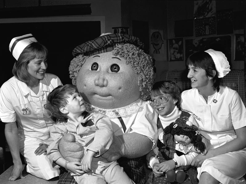A giant Cabbage Patch Kid and 10-year-old Krisha Jacobs (with a Cabbage Patch doll) visit the Sick Children's Hospital in Edinburgh in October 1985