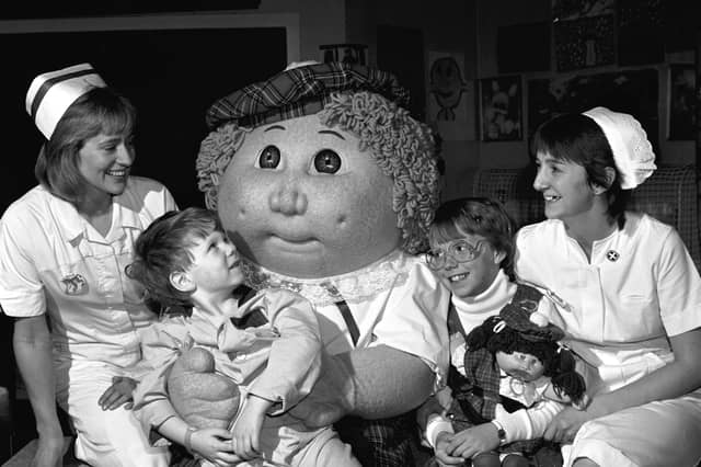 A giant Cabbage Patch Kid and 10-year-old Krisha Jacobs (with a Cabbage Patch doll) visit the Sick Children's Hospital in Edinburgh in October 1985