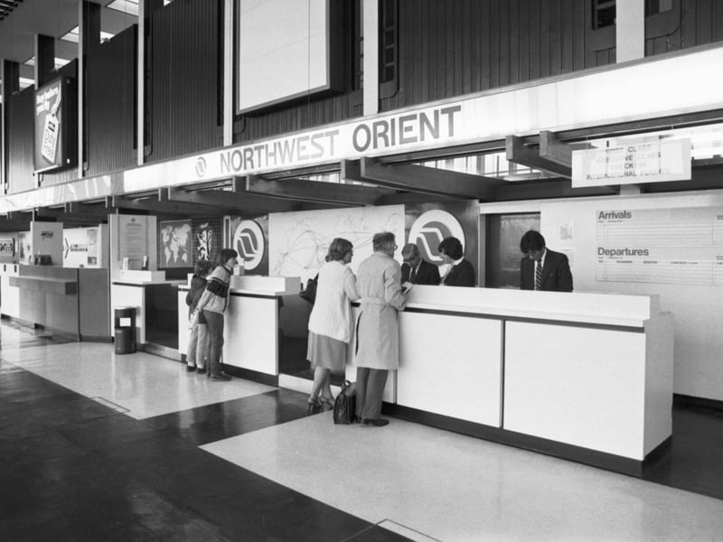Customers at the Northwest Orient airline company's check-in desk at Prestwick airport in May 1984