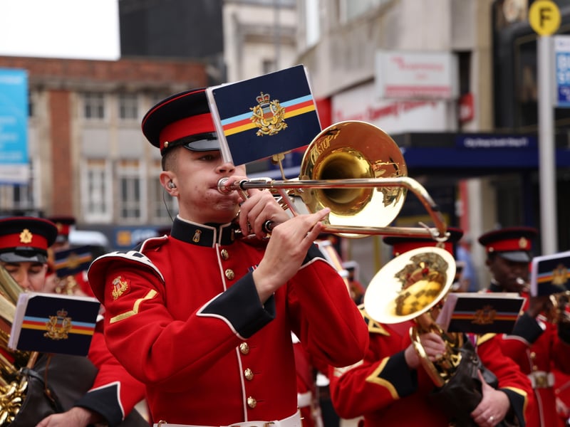 Royal Marines bandmate playing his trumpet as they march through the streets of Portsmouth.