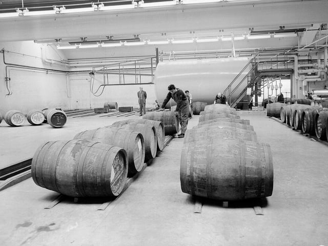 Men rolling barrels at the Chivas whisky plant in Paisley in 1964.