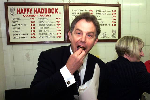 Prime Minister Tony Blair tucks into some fish and chips at the Happy Haddock restaurant in Brighouse, West Yorkshire, in May 2001. Just look at those prices on the wall behind him!